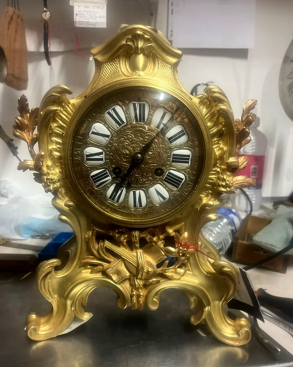 Pendule de cheminée ancienne aux ornements dorés