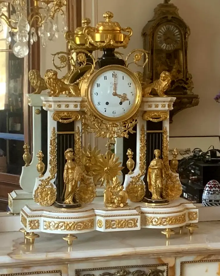 Pendule portique ancienne en marbre clair aux ornements dorés
